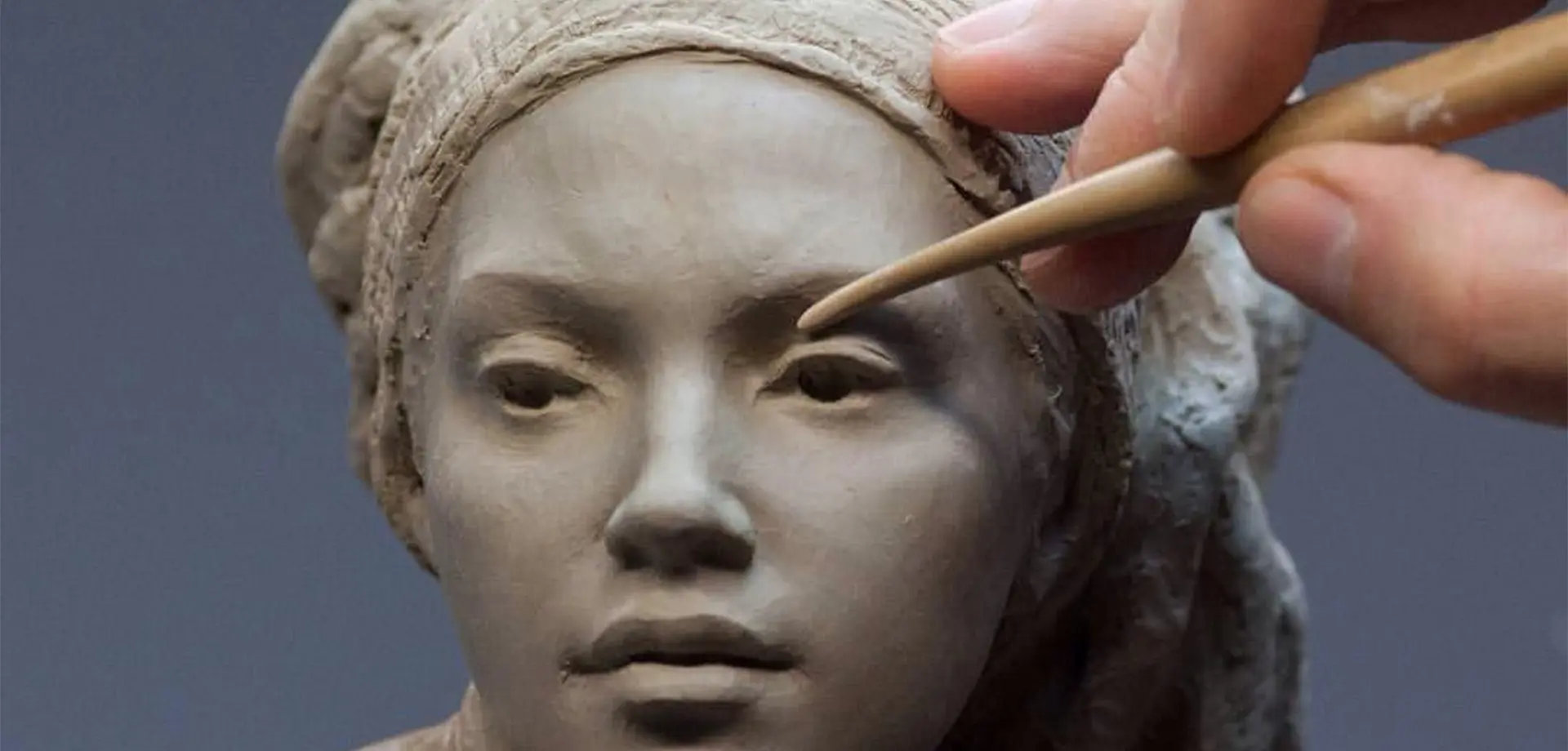 Artist working on a custom bronze sculpture commission in factory studio