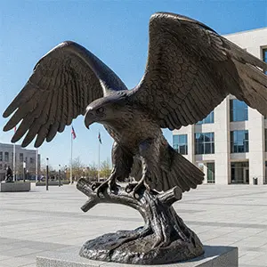 Bronze landing eagle sculpture gripping a branch with open wings