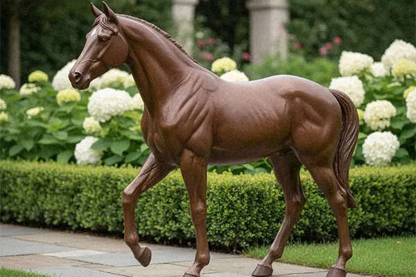 Life-size brown bronze horse garden statue walking on grass