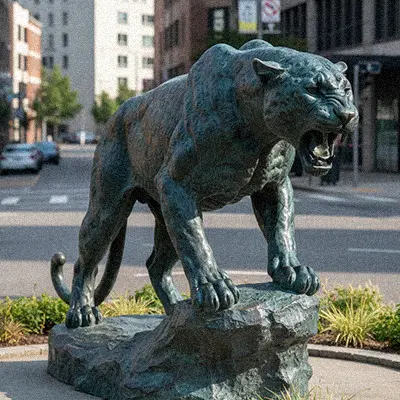 Bronze leopard statue with spots standing on rock