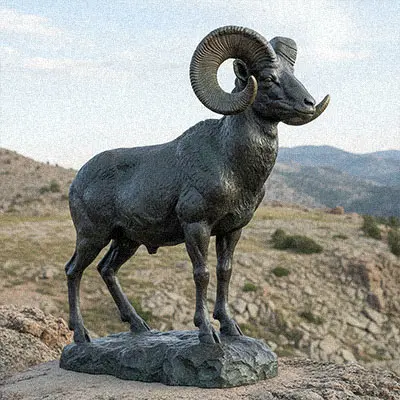 Bronze Bighorn sheep statue standing on rocky base