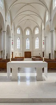 Solid white marble altar table standing in a church nave