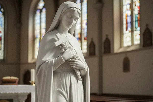 White marble statue of Mary holding a cross for cemetery