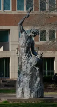 Self-made man bronze statue carving himself out of stone