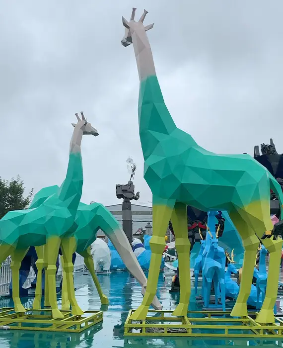 Geometric metal giraffe sculptures painted green and blue modern art