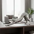 Silver stretching cat sculpture on bookshelf