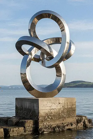 Large outdoor stainless steel ring sculpture by the sea