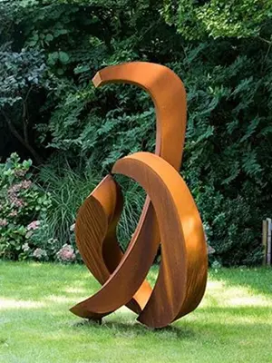 Large abstract corten steel rusty metal sculpture in garden