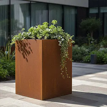 Square corten steel planter box with green plants for street