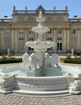 Grand white marble tiered fountain with lion statues in garden