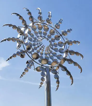 Large stainless steel kinetic wind spinner sculpture moving in wind