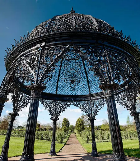 Custom wrought iron birdcage gazebo with dome top in backyard garden