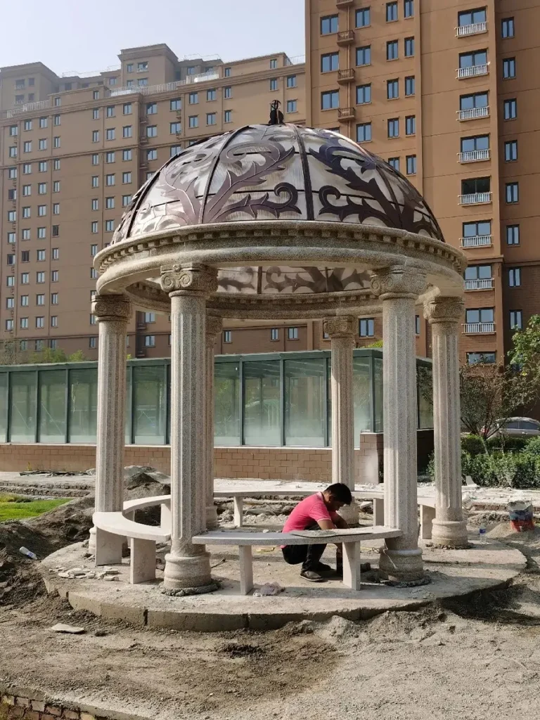 Classical stone garden structure crafted from solid marble and integrated into formal landscape design.