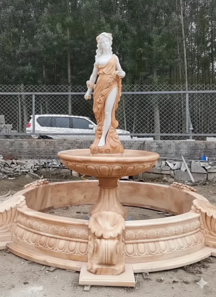 Hand-carved natural marble figure fountain completed inside factory workshop, showing solid stone construction before installation.