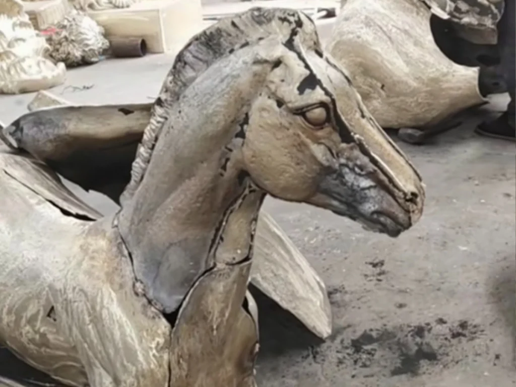 Craftsman hand-chasing bronze horse sculpture to remove weld seams and perfect surface