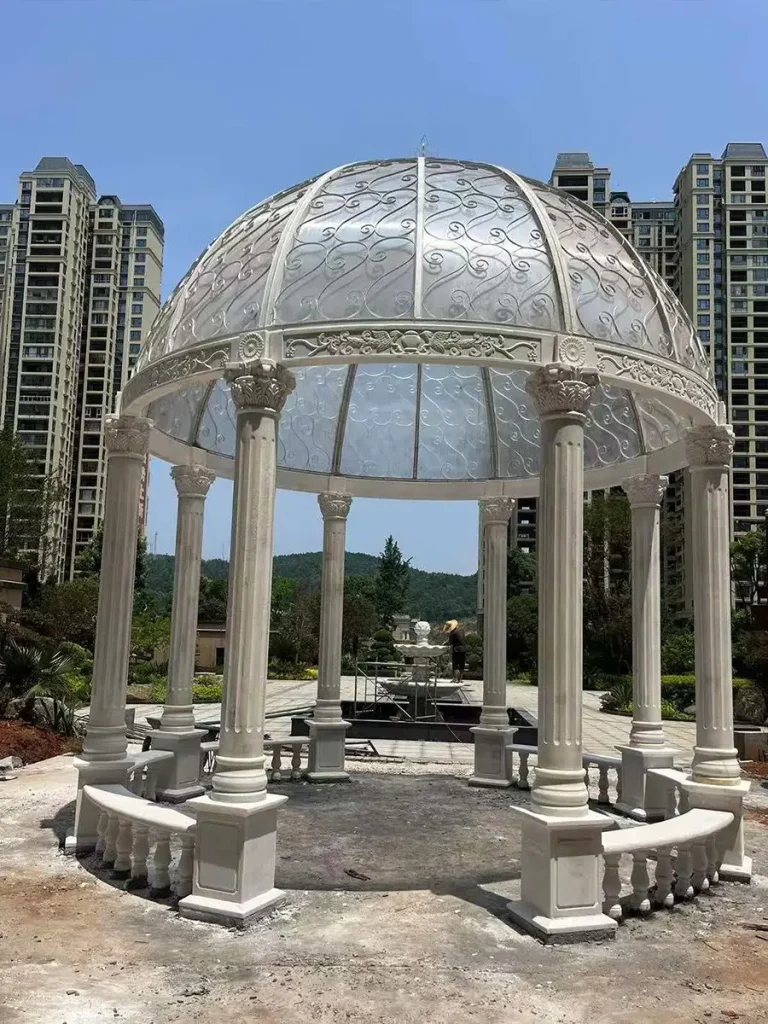 Front view of fully installed marble gazebo in luxury estate garden showing completed custom garden architecture project