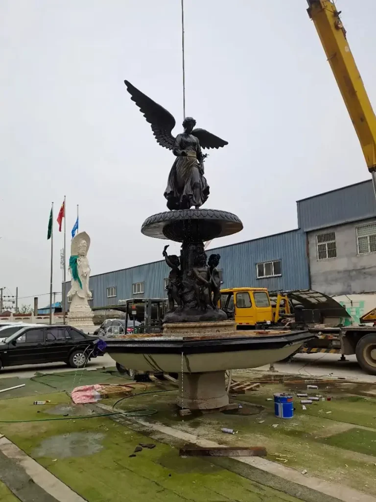 Large outdoor bronze tiered fountain with Angel and Cherub statues, shown at Yun Sculpture factory yard ready for installation and shipping.