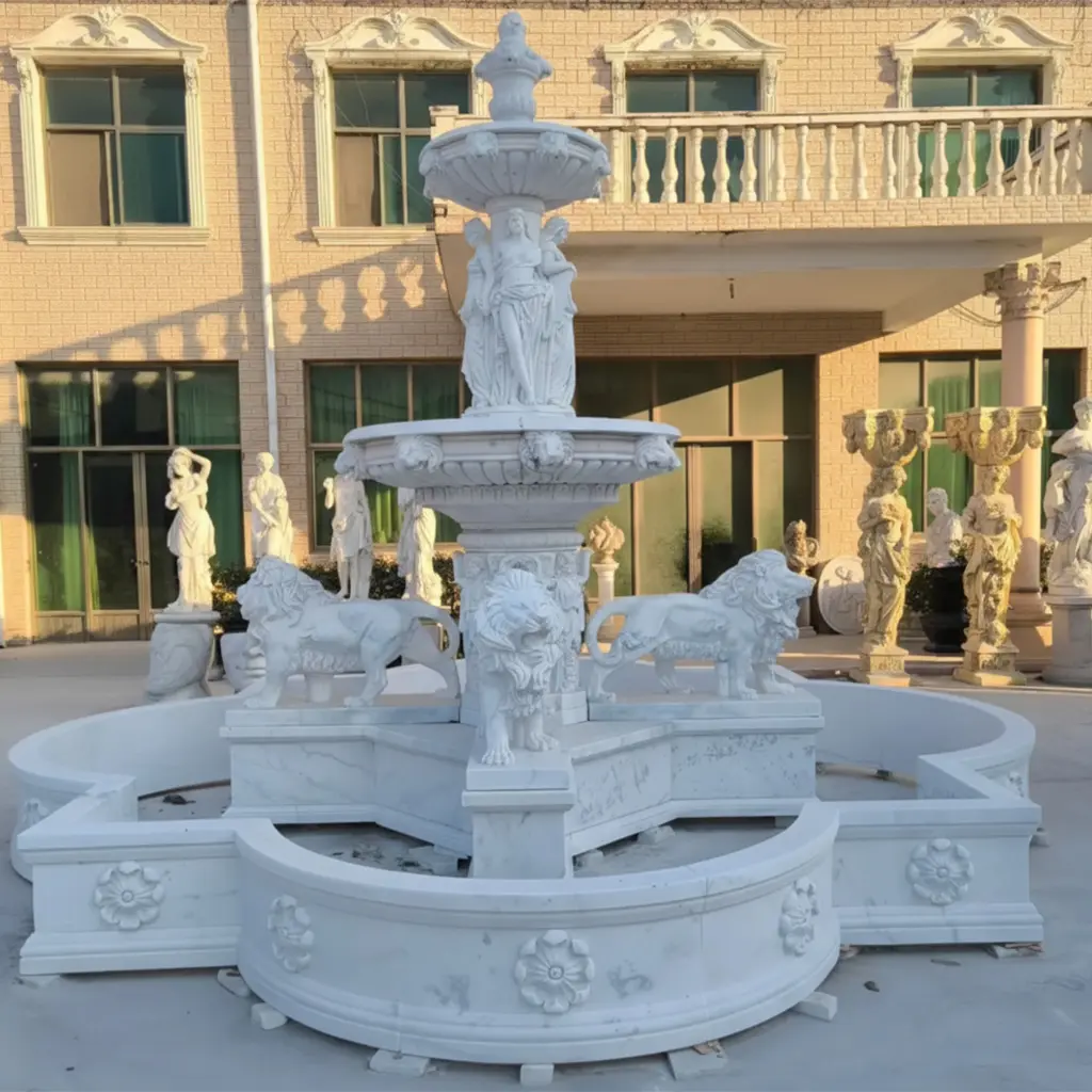 Large outdoor white marble tiered fountain featuring hand-carved lion statues and female figures, installed with a quatrefoil pool basin for luxury estates.