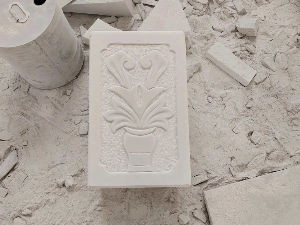Hand carved marble gazebo pedestal with deep floral relief detailing showing custom stone carving craftsmanship and structural base design