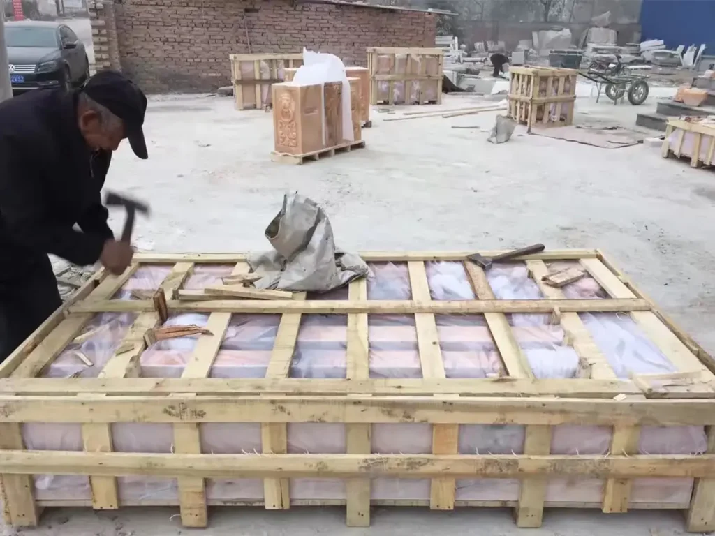 Close-up of marble gazebo pieces wrapped with protective foam and secured for safe overseas transportation.