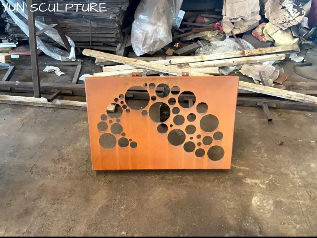 An unfinished rustic iron wall sculpture featuring abstract circular cutouts, demonstrating how heavy metal utilizes negative space to create a visually light presence.