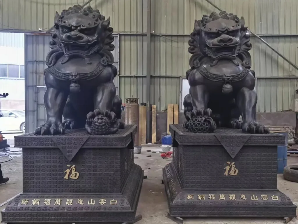 A completed pair of bespoke dark bronze Foo Dogs mounted on large, decorative matching pedestals. Custom-crafted by Cloud Sculpture Studio, these majestic outdoor guardian lions feature the Chinese character for "Blessing" (Fu) on their bases, providing a dramatic impact for large luxury homes.