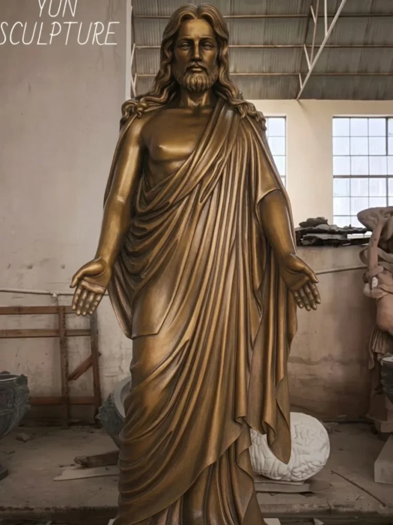 A big Jesus statue standing in the workshop, specifically scaled for outdoor courtyard installation and as a landmark for pilgrimage destinations.