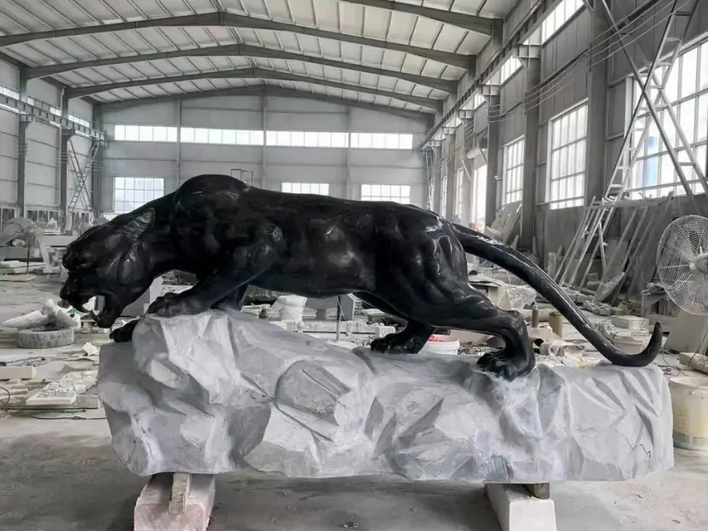 Black panther sculpture walking in a stealthy posture in a modern luxury garden landscape