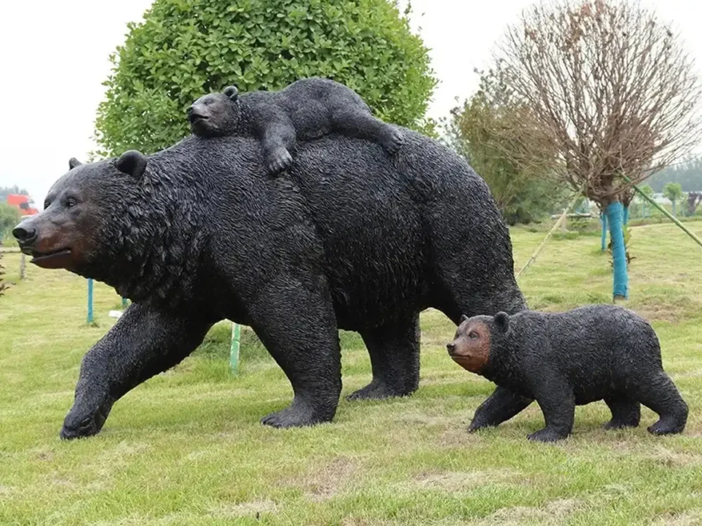 A lifelike bronze sculpture of a mother bear calmly walking across a garden lawn with her two cubs. This natural, non-aggressive posture perfectly embodies the quiet strength and ancestral presence often chosen by private estates to guard family legacy and bloodlines.