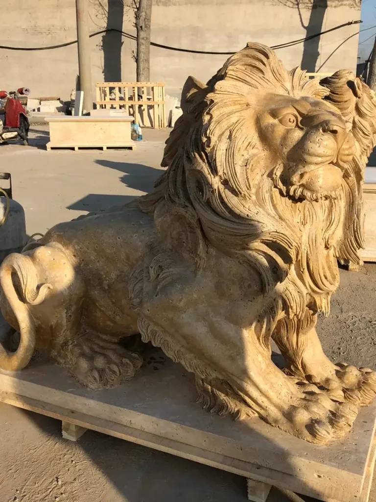 A stunning side view of a resting yet alert lion carved from porous yellow marble. The harsh natural sunlight perfectly highlights the realistic shoulder tension, bone structure, and the deep, lifelike carving of the flowing mane against a workshop background.