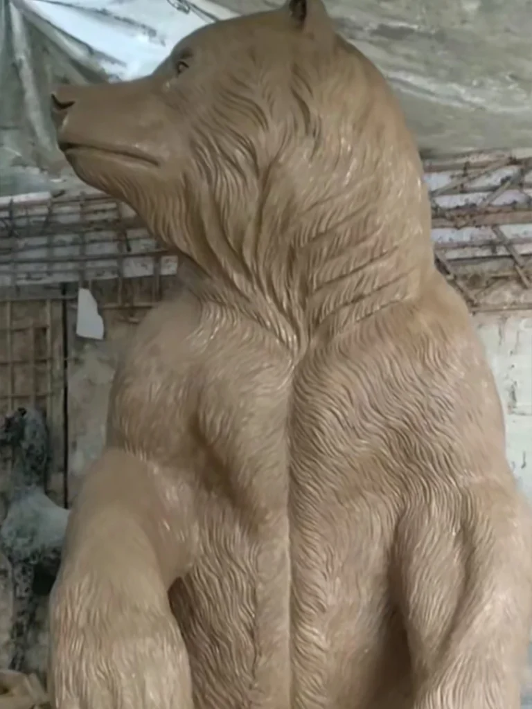 Close-up of the clay prototype for a monumental bear statue, highlighting its powerful chest muscles and calm facial expression. Mastering these intricate handcrafted details in clay is essential to achieving the breathtaking realism seen in high-quality outdoor wildlife sculptures.