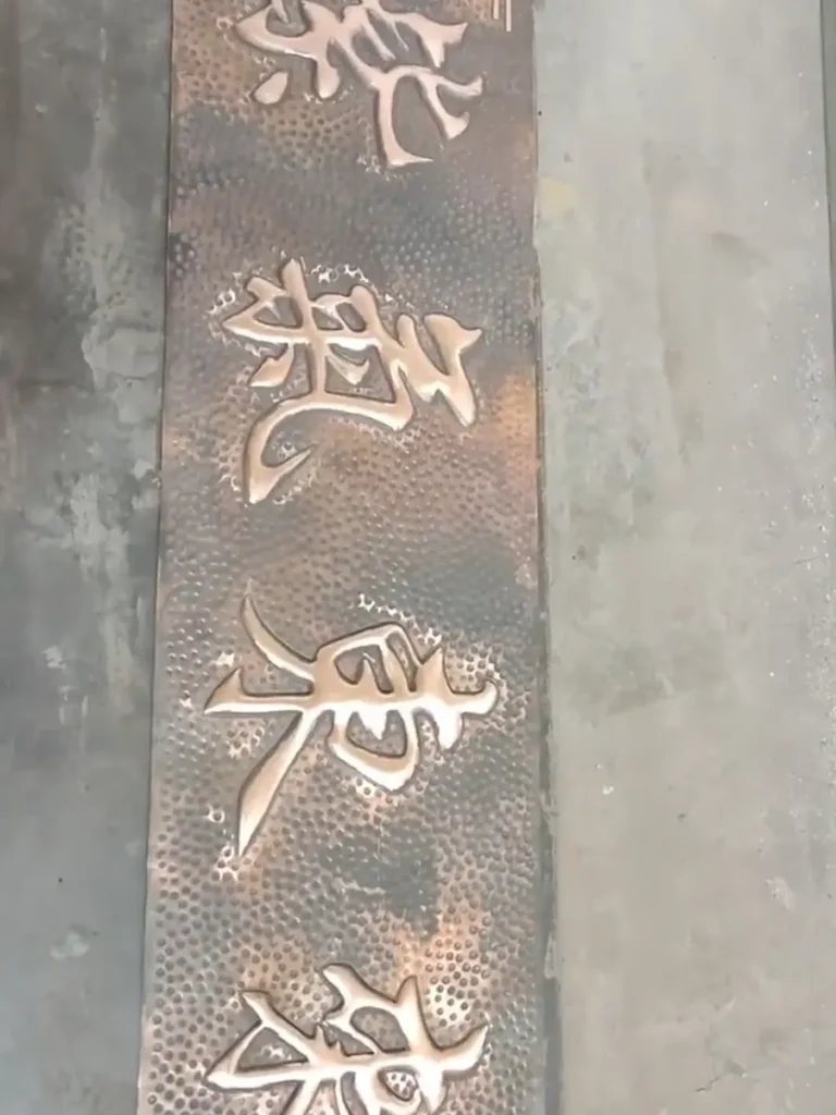 The raw copper relief is fully shaped, proudly displaying the artisan's handiwork. It now awaits the final chemical patina application to achieve its weather-resistant finish.