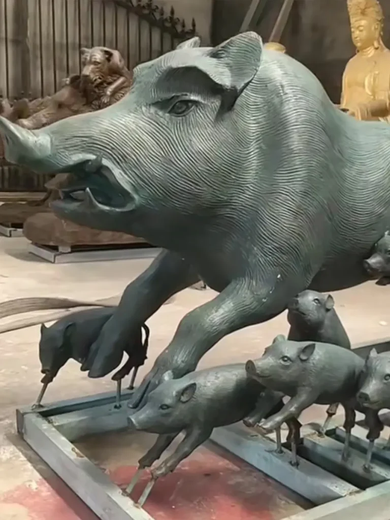 A dynamic bronze wild boar sculpture running alongside energetic piglets in a foundry. With its lowered head and muscular build, this statue symbolizes determination and power, perfectly capturing the untamed energy of the forest for a woodland garden trail.