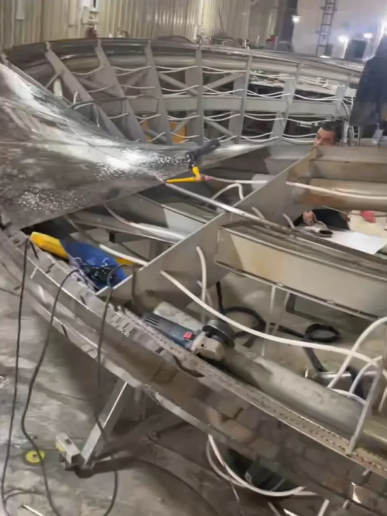 An inside look at the highly engineered internal ribs and supports of a monumental stainless steel sculpture. Functioning much like a heavy-duty bridge truss, this invisible framework is calculated to prevent deformation and withstand extreme wind loads in open commercial plazas.