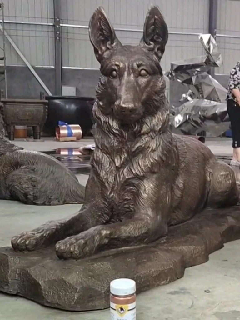 Finished bronze German Shepherd statue with a classic antique brown patina, sitting on a bronze base, ready for outdoor installation.