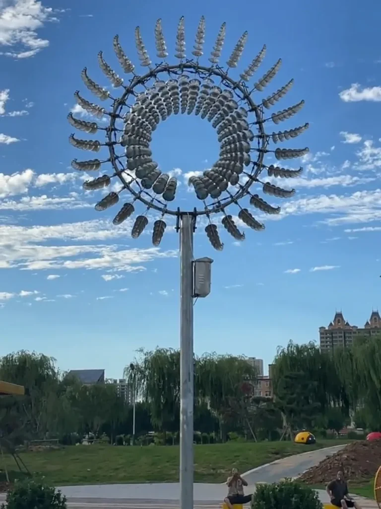 A fully dynamic kinetic stainless steel wind sculpture with its elements forming a swirling vortex pattern. The reflections of the environment are completely fragmented and dissolved into a mesmerizing Liquid Silver effect.