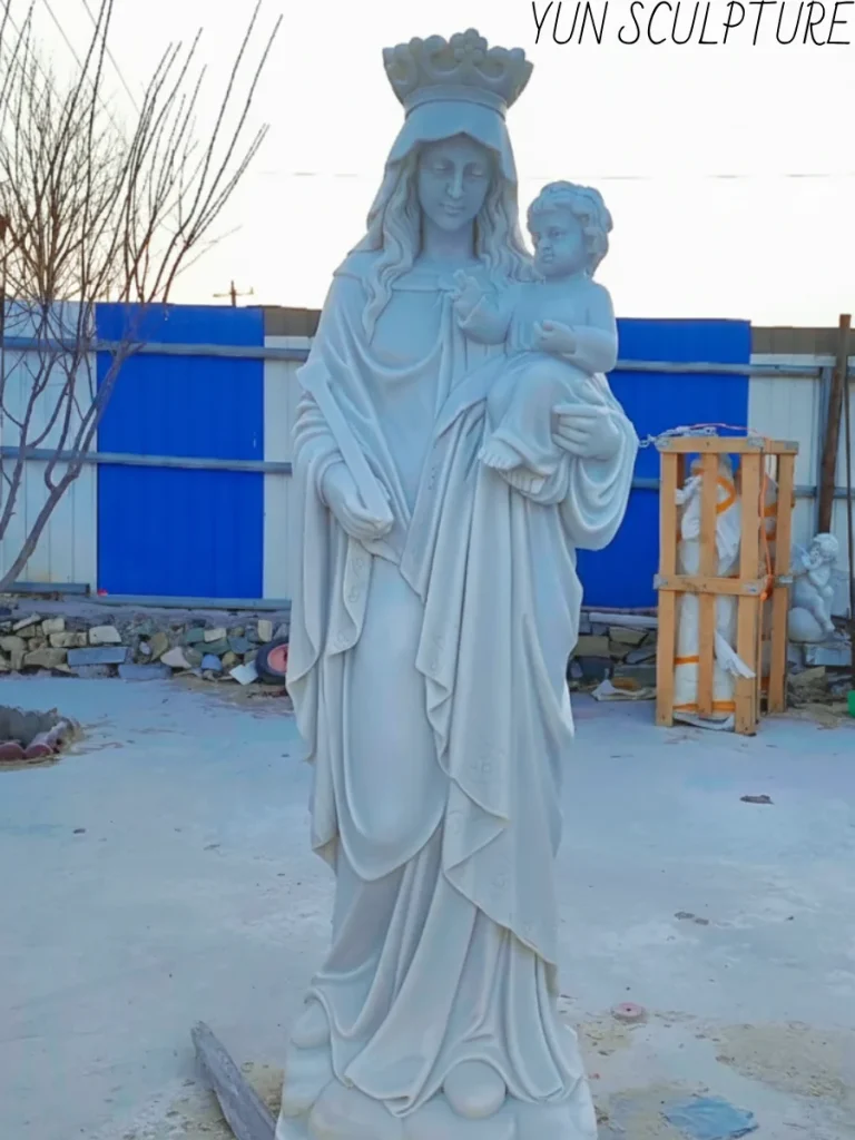 A full-length hand-carved white marble Mary holding baby Jesus statue, showcasing the luminous quality of Hanbaiyu or Carrara marble for interior chapel installation.