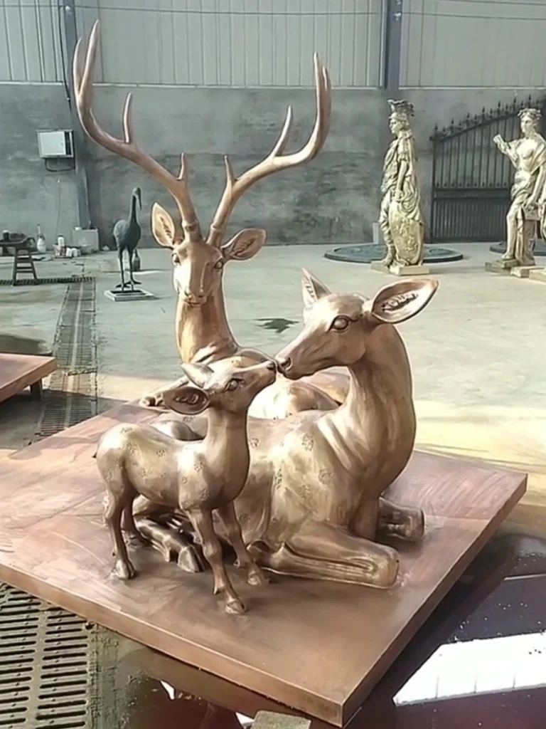 Close-up of a bronze doe and fawn gently interacting within a family sculpture group. The lost-wax casting technique perfectly preserves the gentle facial expressions and fine coat spots, creating a highly durable, weather-resistant artwork designed to be displayed outdoors for generations.