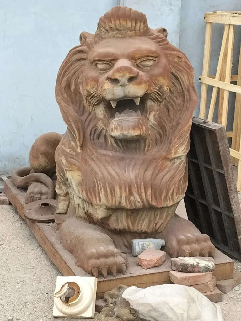 A large, heavy cast iron lion statue resting in a factory yard, serving as a classic example of an estate guardian that becomes a long-term structural investment when proper maintenance protocols are followed.