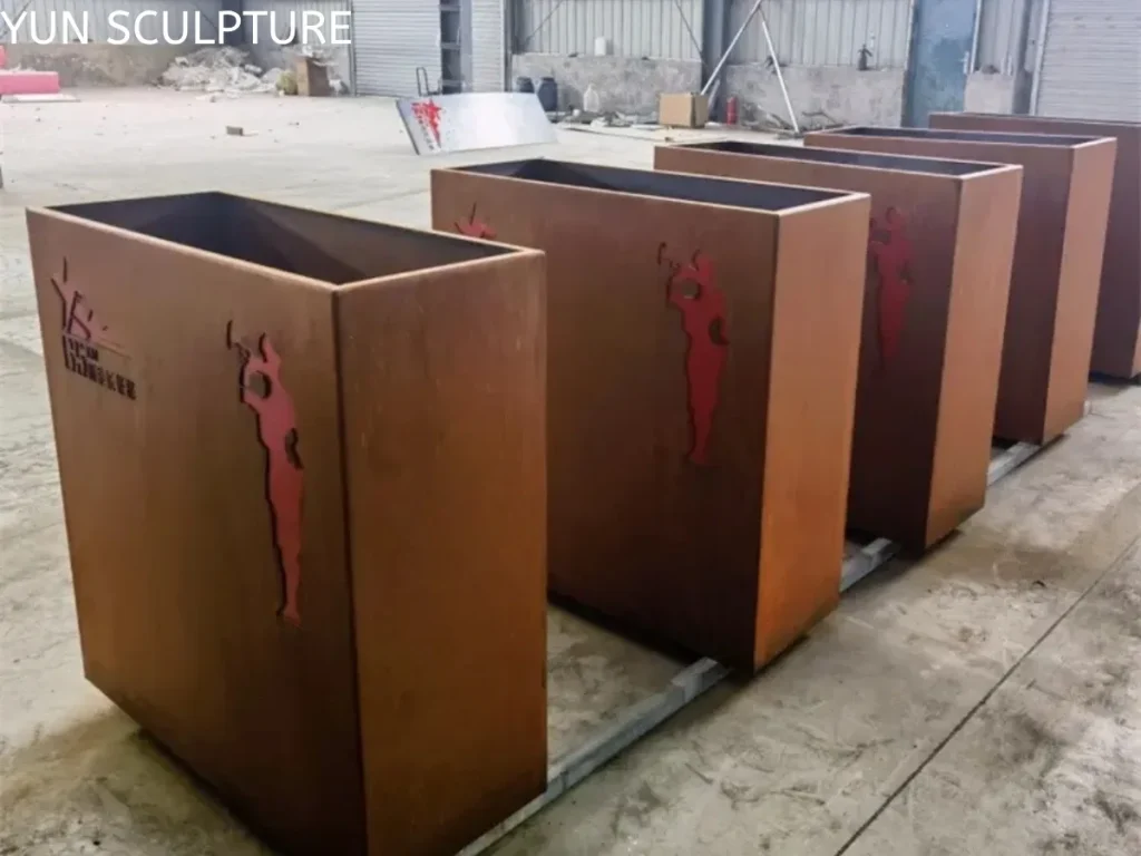 Row of custom corten steel planter boxes in factory ready for shipping