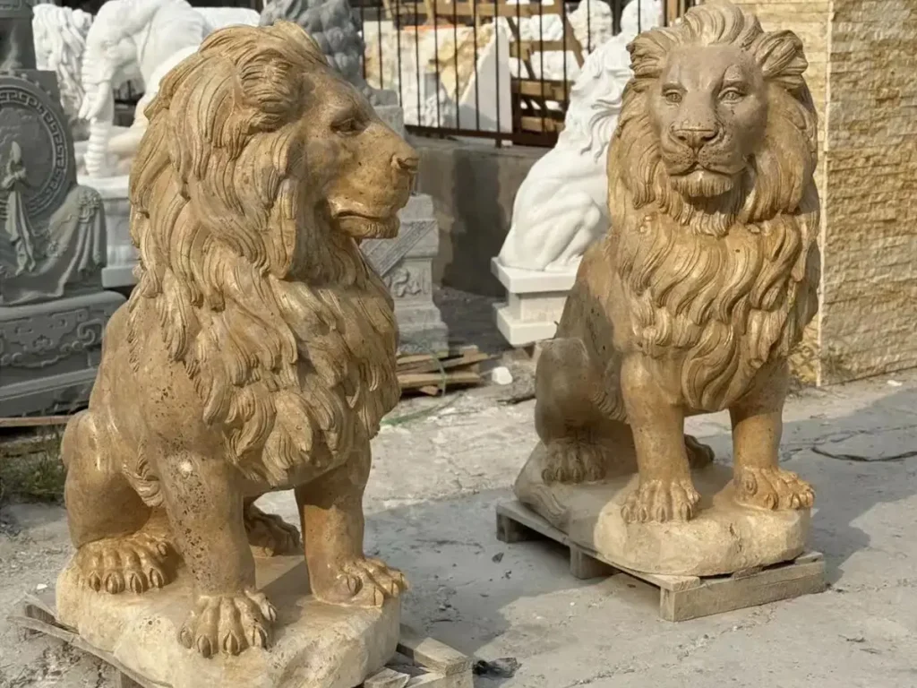 A pair of large yellow marble sitting lion statues designed for grand entrances, projecting calm authority and high social status.