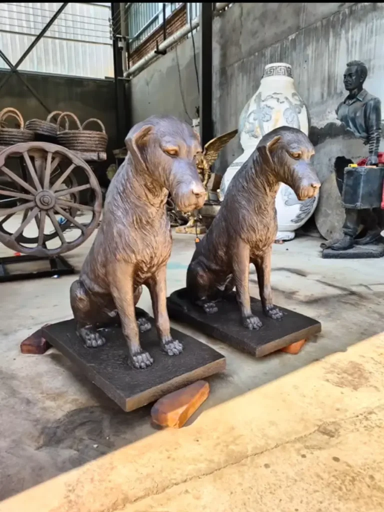Hand-carved life size bronze Labrador dog sculptures sitting in our workshop, ready for outdoor garden landscaping.