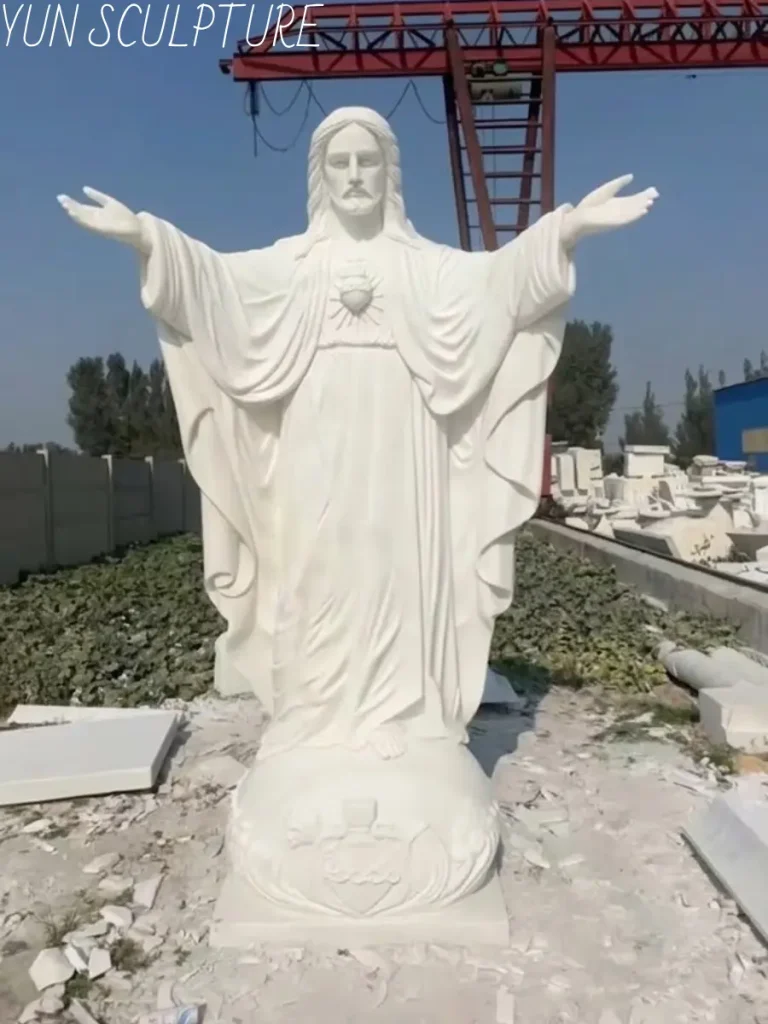 A magnificent, fully carved life-size marble Jesus statue with outstretched arms standing outdoors, embodying stillness and purity, ready for a garden or memorial installation.