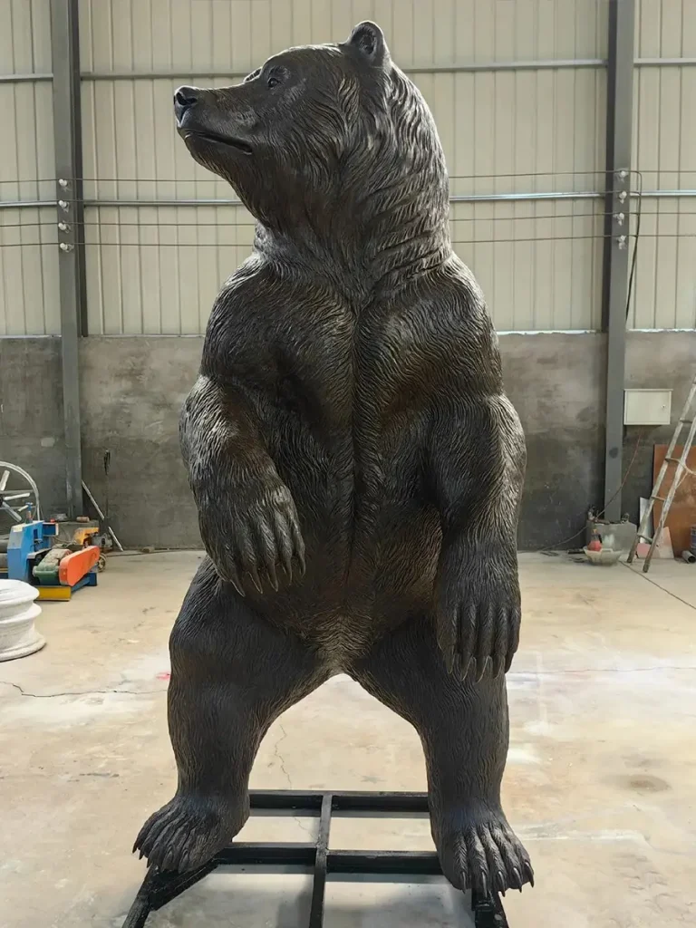 Life-size bronze grizzly bear statue standing upright in foundry workshop