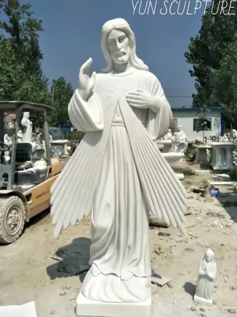Frontal view of a breathtaking, newly carved white jesus marble statue standing majestically in a sunny factory yard. The gleaming white stone perfectly embodies a cooler, more luminous aesthetic with a translucent depth that no cast bronze can replicate, making it an exquisite masterpiece destined exclusively for an interior sanctuary.