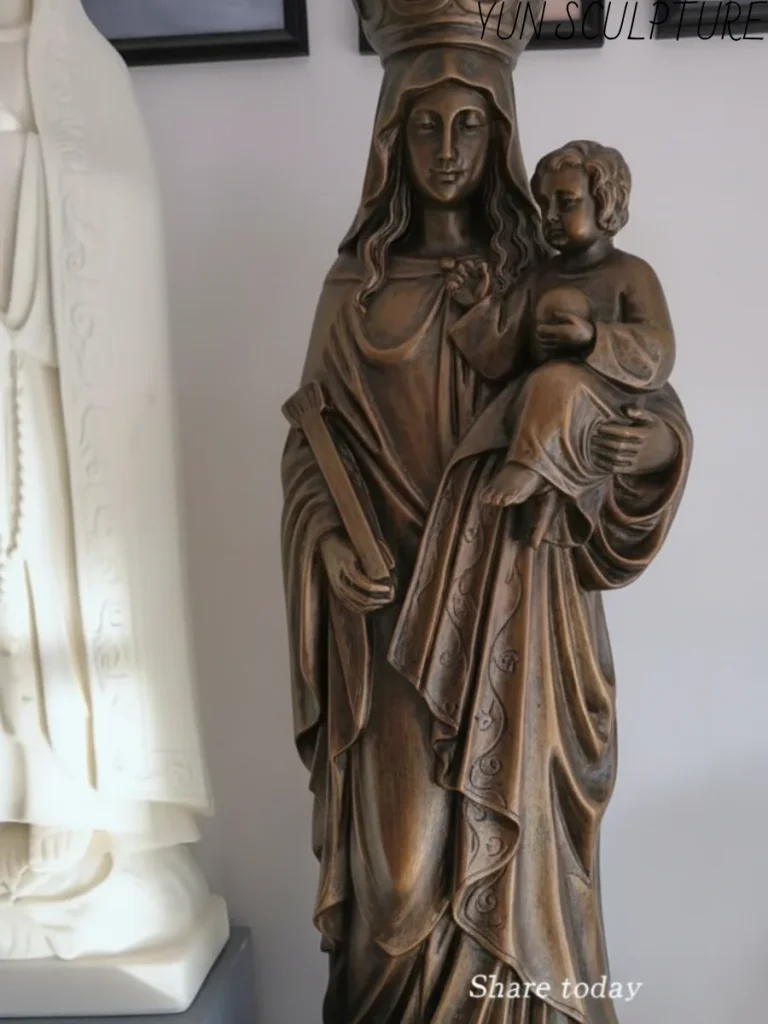 A handcrafted bronze Madonna and Child statue featuring the Virgin Mary holding the infant Jesus, emphasizing a tender and intimate devotional expression.