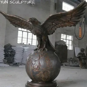 A majestic cast iron eagle statue with outspread wings perched on a globe, designed as a powerful estate icon that embodies vision and vigilance for grand entrances.