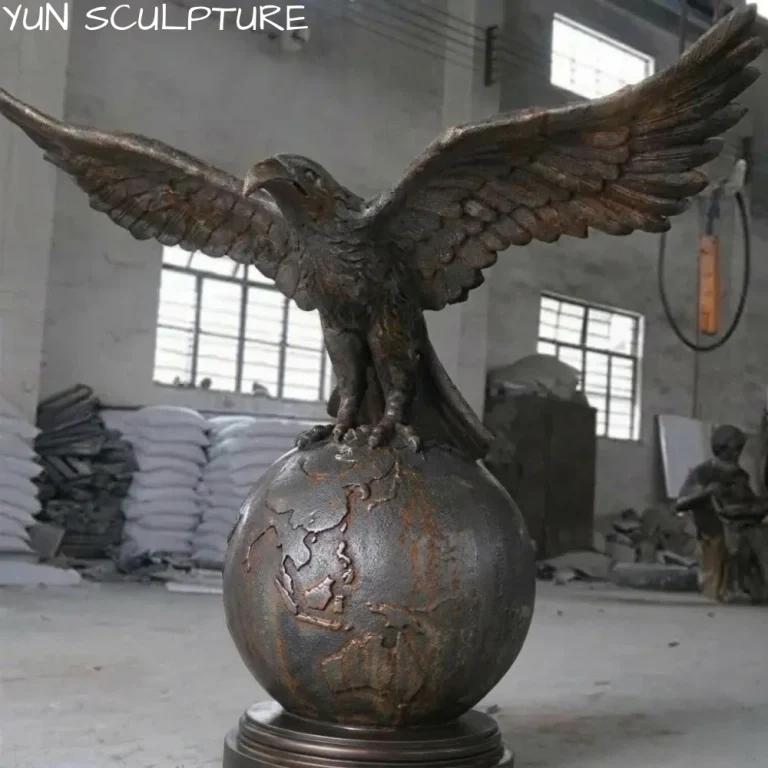 A majestic cast iron eagle statue with outspread wings perched on a globe, designed as a powerful estate icon that embodies vision and vigilance for grand entrances.