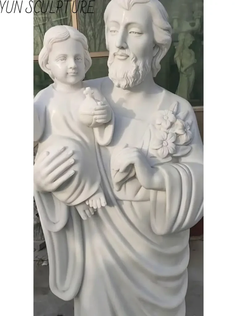 Hand-carved marble statue of Saint Joseph holding the Christ Child, acting as the compositional anchor for a family group.