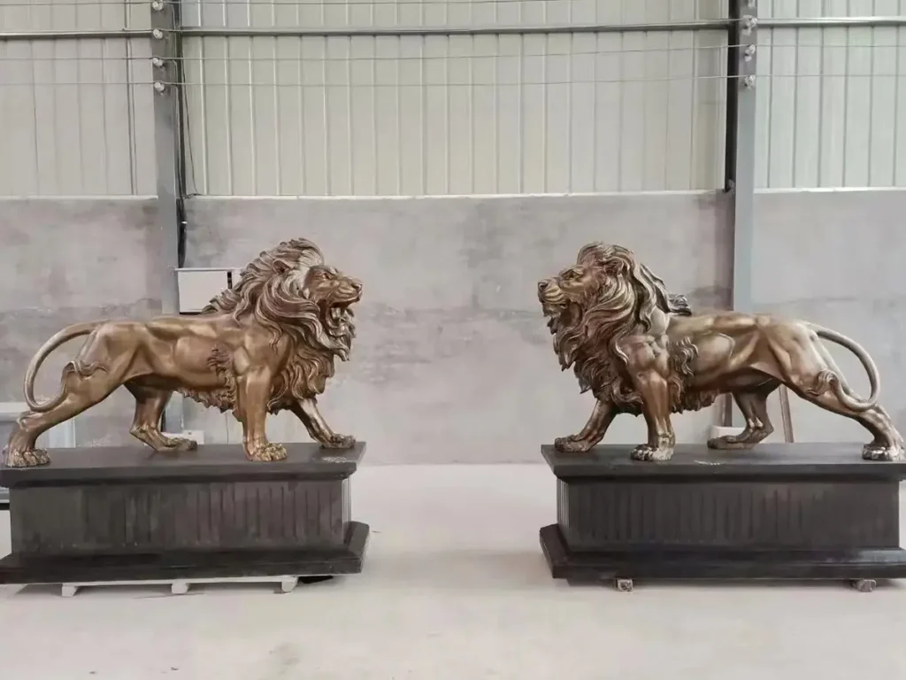 A magnificent matching pair of finished bronze guardian lions mounted on dark bases in a workshop. Representing the ultimate benchmark of nobility and craftsmanship, these premium metal sculptures are ready to bring a sense of history to a luxury estate entrance.